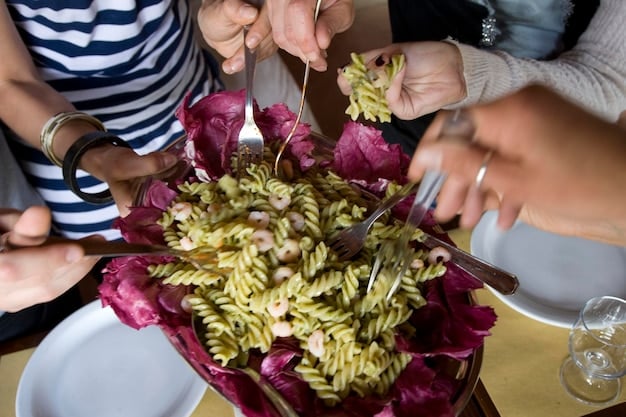 A group of tourists participates in a traditional cooking class in Tuscany, Italy. They are learning to make pasta from scratch under the guidance of a local chef in a rustic Italian kitchen.