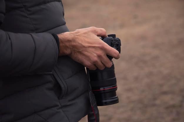 A close-up shot of a photographer using a long telephoto lens to photograph a perched bald eagle in Acadia National Park, maintaining a respectful distance and using natural light to avoid disturbing the bird. The focus is on the eagle's intense gaze and the photographer's unobtrusive approach.