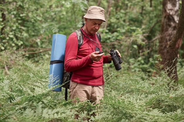 A backpacker using a water filter to purify water from a stream in a national park. The backpacker is wearing appropriate hiking clothing and is surrounded by lush vegetation.