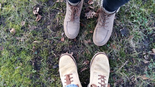 A split image showcasing two different pairs of hiking boots. On one side, a lightweight hiking shoe with breathable mesh on a park trail. On the other side, a sturdy backpacking boot with a high ankle and thick sole on rough terrain.