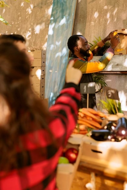 A bustling farmers market with vendors selling local produce, crafts, and artwork. People are sampling the food and browsing the stalls, and live music is playing in the background. The scene captures the vibrant and community-focused atmosphere.