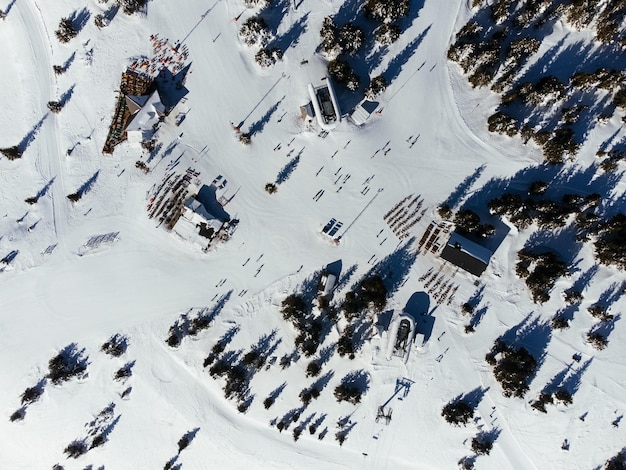 An aerial view of Park City, Utah, covered in snow, with skiers and snowboarders visible on the slopes, showcasing the town’s reputation as a premium winter sports destination. The image also captures the charming architecture of the town's Main Street.