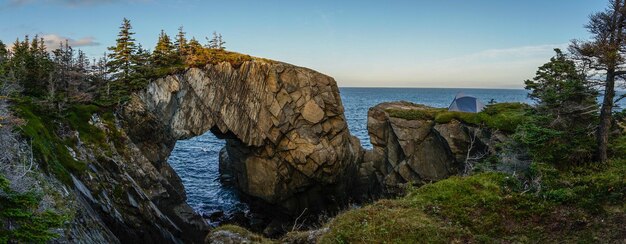 A panoramic view of Acadia National Park in Maine, showcasing the rugged coastline, granite peaks, and lush green forests. The image should capture the park's dramatic scenery and natural beauty.