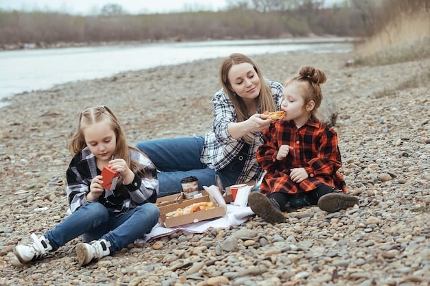 A scenic shot of a family enjoying their packed snacks during a roadside picnic. They are sitting on a blanket, surrounded by nature, and laughing as they eat. The focus is on the joy of sharing healthy food and experiences together while traveling.