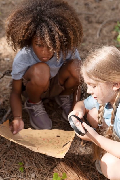 A diverse group of children participates in a Junior Ranger program, learning about ecology at a wooden table outdoors with a park ranger.
